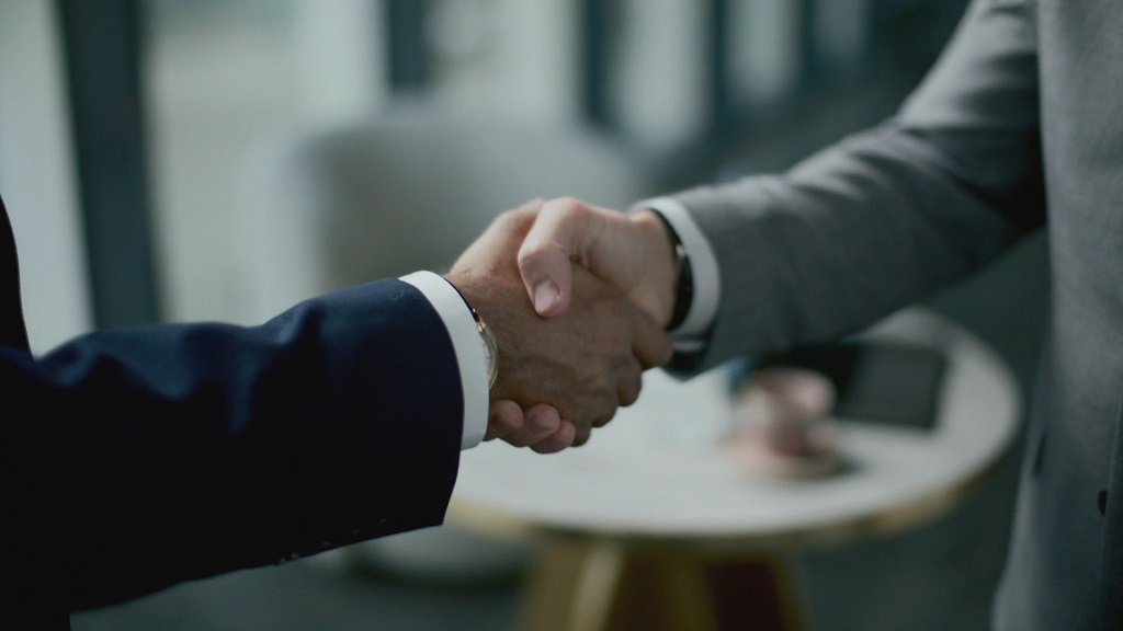 Business professionals shaking hands after client retention strategy meeting