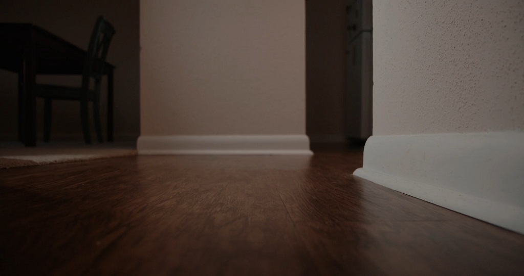 Continuous wood flooring running through adjacent rooms, creating visual flow and a sense of expanded space